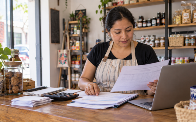 Dueña de una pequeña empresa revisa en una libreta los cobros y pagos de las próximas semanas.