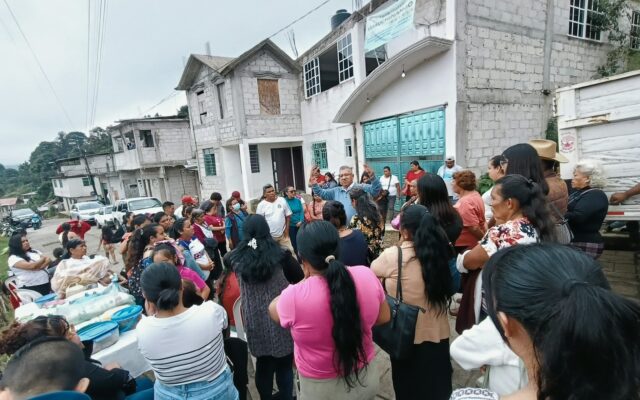 Un hombre habla con vecinas y vecinos reunidos en una colonia de Huauchinango.